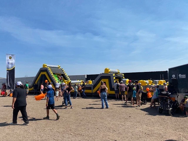 Crowd at Big Dig 2024, with an inflatable obstacle course in the background.