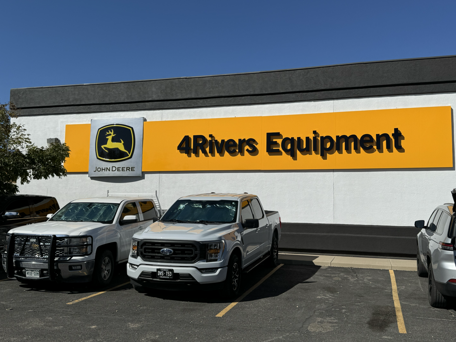 4Rivers Equipment sign outside of one of the stores, with 4Rivers pickup trucks sitting in the parking lot.